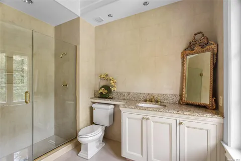 a bathroom with a granite countertop sink toilet and shower