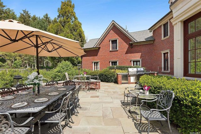 a view of a patio with couches table and chairs under an umbrella