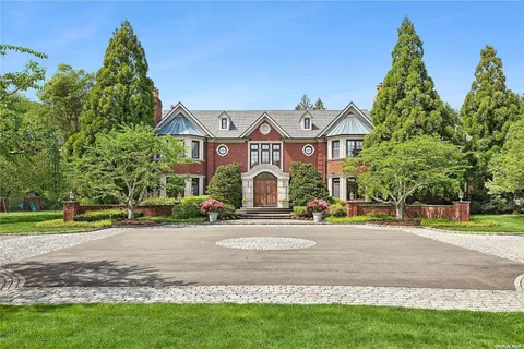 a front view of a house with a yard and potted plants