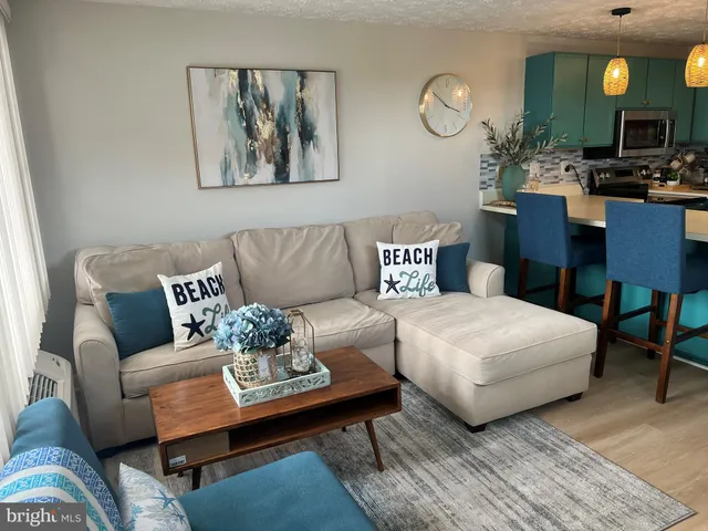 a living room with furniture a lamp paintings and a window