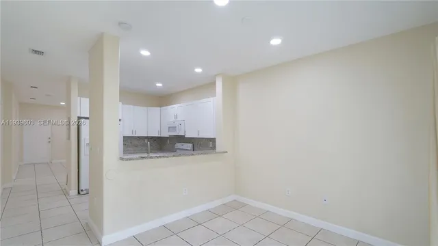 a view of a kitchen with white cabinets