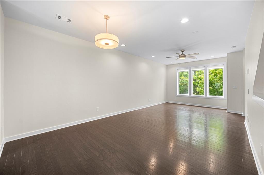 415 Gartrell Street Southeast, Unit 16 Atlanta, GA 30312 - Photo 12 of 29 an empty room with wooden floor and windows