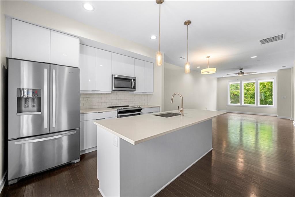 415 Gartrell Street Southeast, Unit 16 Atlanta, GA 30312 - Photo 10 of 29 a kitchen with stainless steel appliances a refrigerator a stove a sink and a center island