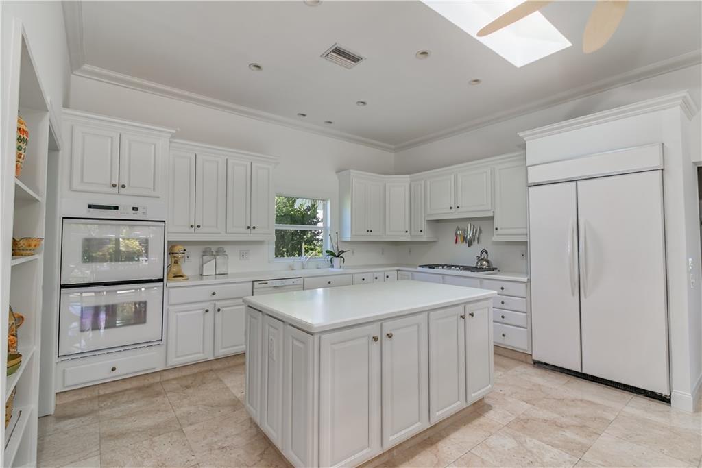 12 Heron's Nest Stuart, FL 34996 - Photo 16 of 43 a kitchen with white cabinets and white appliances