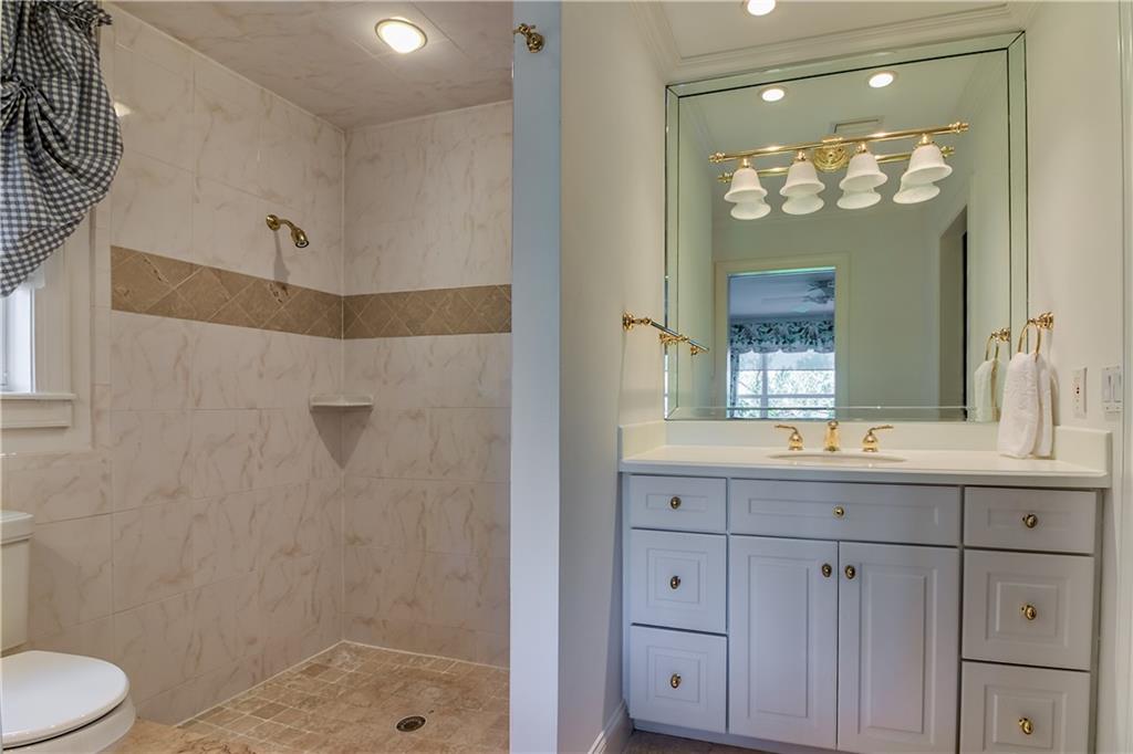 12 Heron's Nest Stuart, FL 34996 - Photo 33 of 43 a bathroom with a granite countertop sink a toilet and a mirror