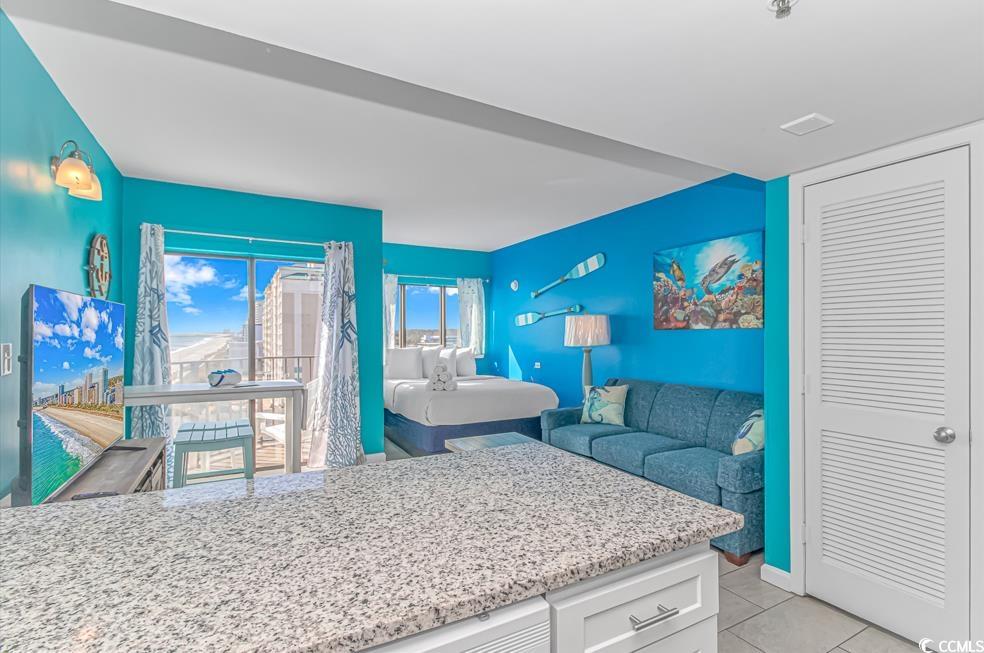 1605 South Ocean Boulevard, Unit 705 Myrtle Beach, SC 29577 - Photo 34 of 38 Kitchen featuring white cabinets, light stone countertops, and light tile patterned floors