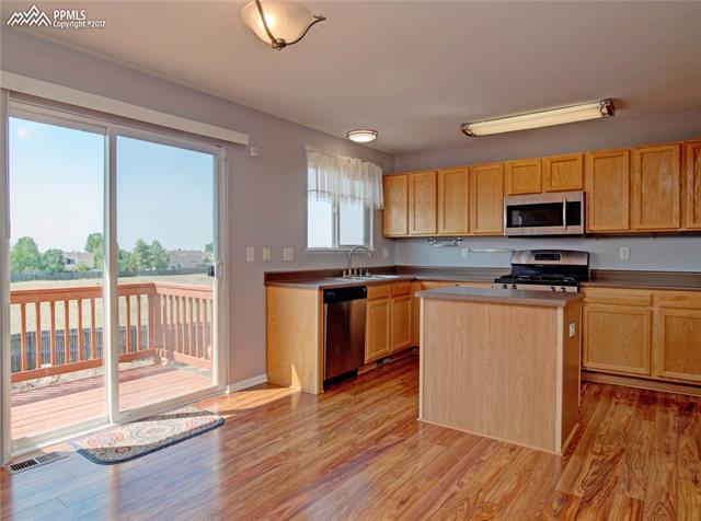 7680 Tompkins Road Peyton, CO 80831 - Photo 12 of 30 Kitchen with Island, Stainless Steel Appliances, walk out to Deck.