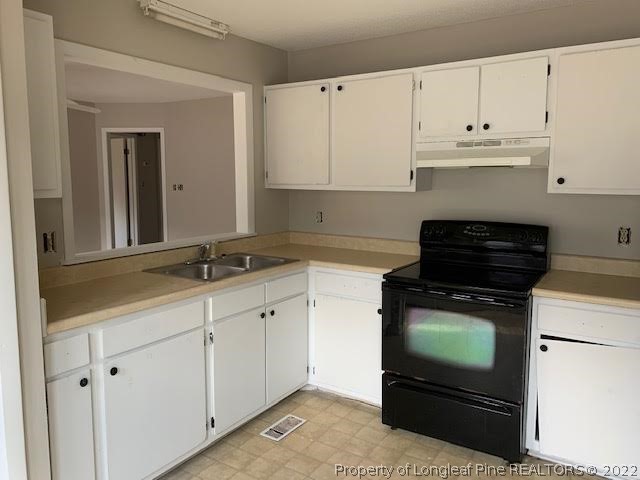 3331 Arrowhead Road Spring Lake, NC 28390 - Photo 10 of 15 a kitchen with white cabinets and black appliances