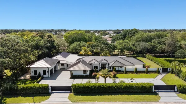 an aerial view of a house with swimming pool and big yard