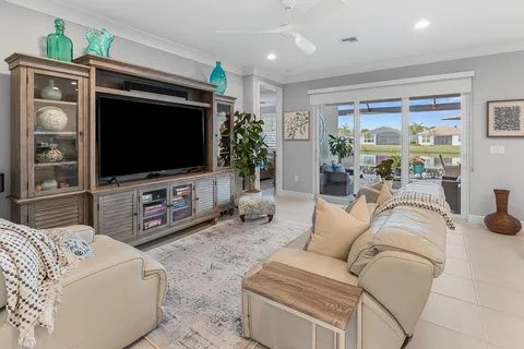 a kitchen with granite countertop kitchen island stainless steel appliances a stove top oven a sink a refrigerator white cabinets and wooden floor