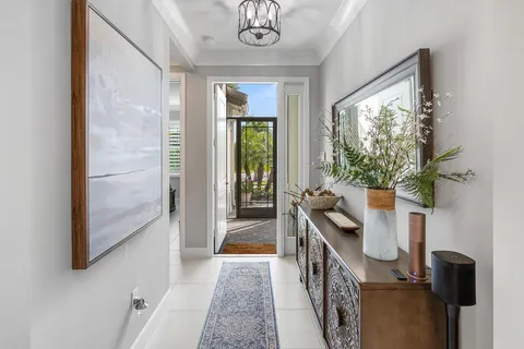 a bedroom with a bed a computer on the desk and a potted plant