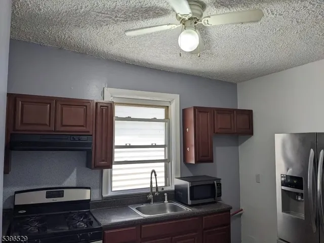 a kitchen with stainless steel appliances granite countertop a refrigerator and a stove top oven