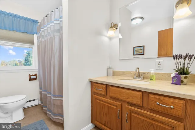 a bathroom with a granite countertop sink a toilet and a mirror