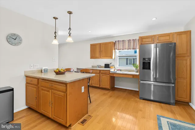 a kitchen that has a lot of cabinets and wooden floor