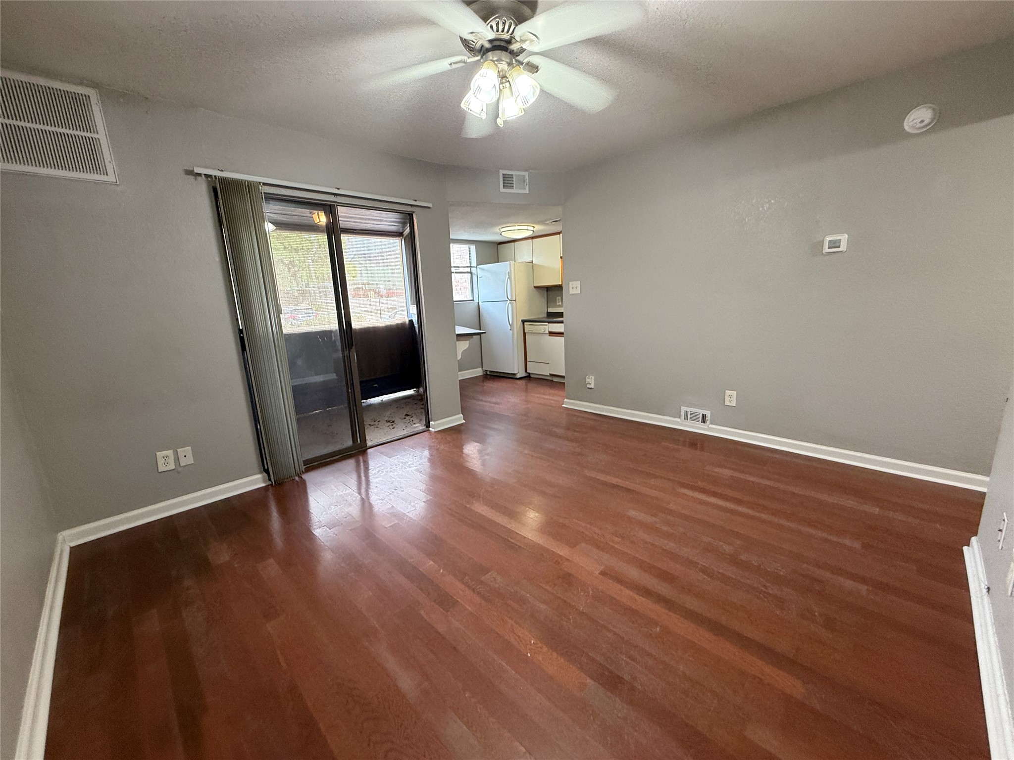 2500 Burleson Road, Unit 209 Austin, TX 78741 - Photo 4 of 15 Gleaming hardwood floors and a sliding glass door define this inviting living space.