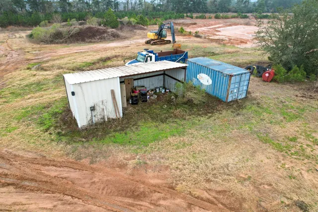 an aerial view of residential houses with outdoor space and trees