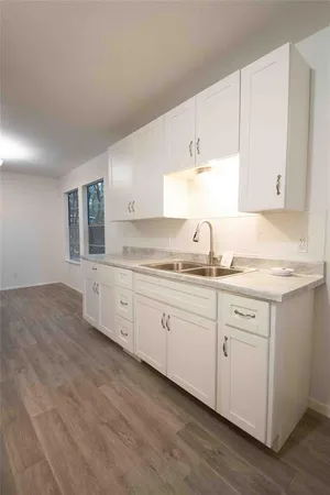 a kitchen with granite countertop white cabinets and white stainless steel appliances