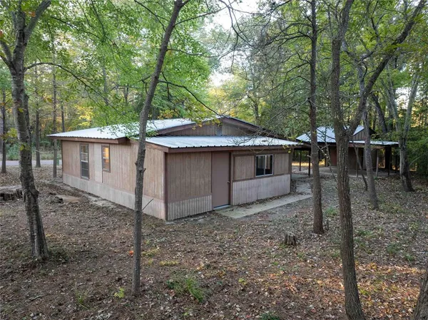 a view of a house with a yard and large tree