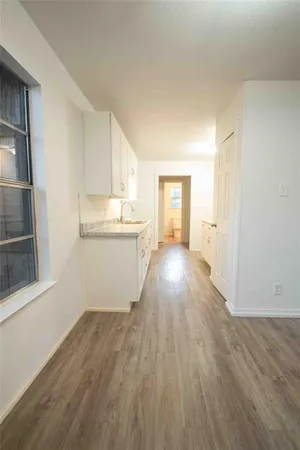 a view of a kitchen with wooden floor and electronic appliances