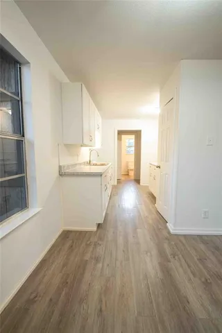 a view of a kitchen with wooden floor and electronic appliances