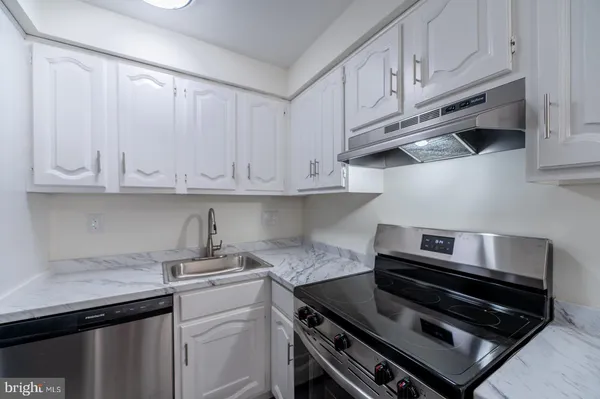 a kitchen with stainless steel appliances granite countertop a sink a stove and cabinets