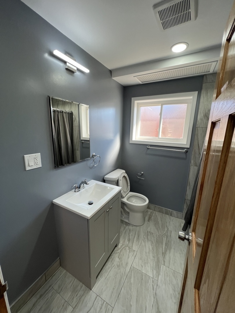 4148 West 87th Street Chicago, IL 60652 - Photo 11 of 16 a bathroom with a sink mirror and toilet