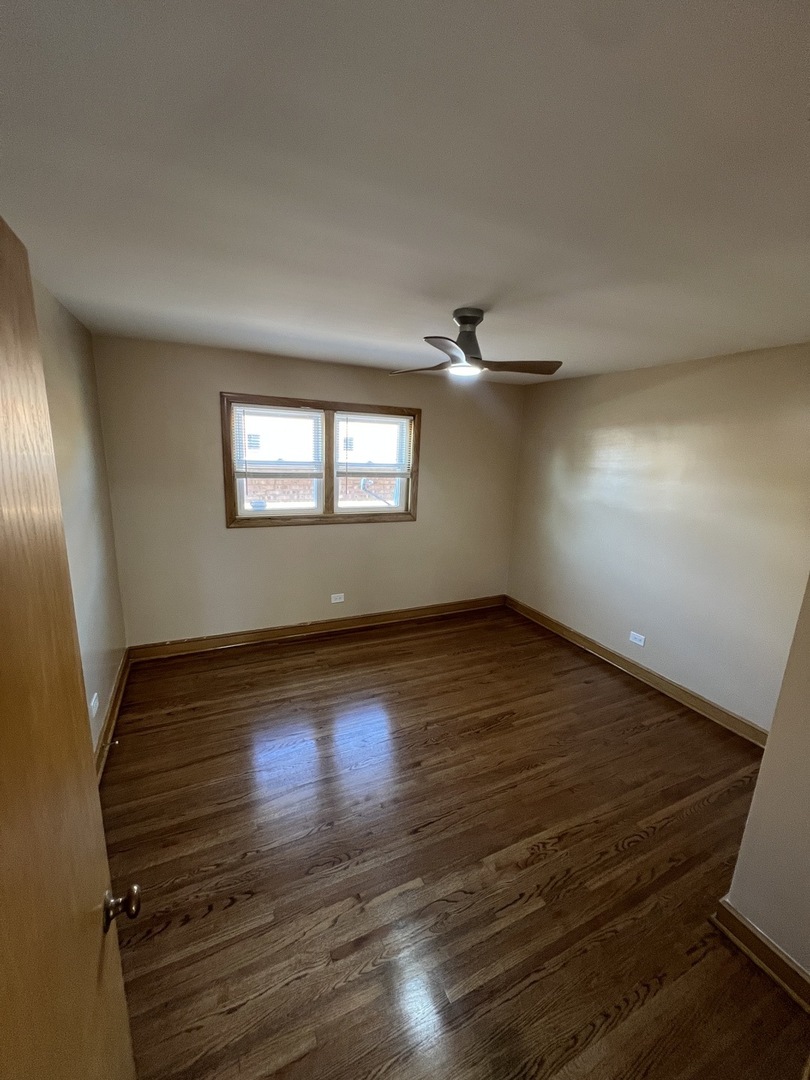 4148 West 87th Street Chicago, IL 60652 - Photo 13 of 16 an empty room with wooden floor and windows