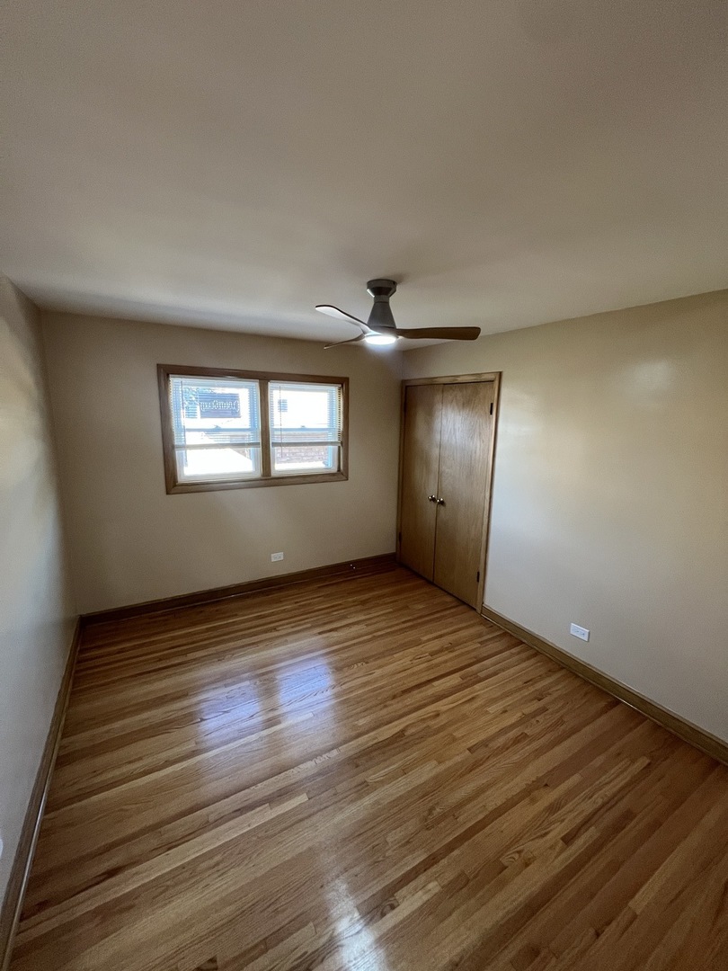 4148 West 87th Street Chicago, IL 60652 - Photo 15 of 16 a view of an empty room with wooden floor and a window