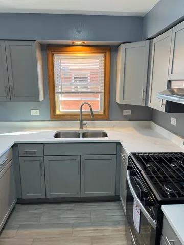 a kitchen with a sink stove top oven and cabinets