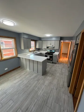 a kitchen with stainless steel appliances granite countertop a stove a sink and a refrigerator