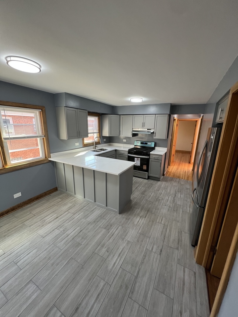 4148 West 87th Street Chicago, IL 60652 - Photo 10 of 16 a kitchen with stainless steel appliances granite countertop a stove a sink and a refrigerator