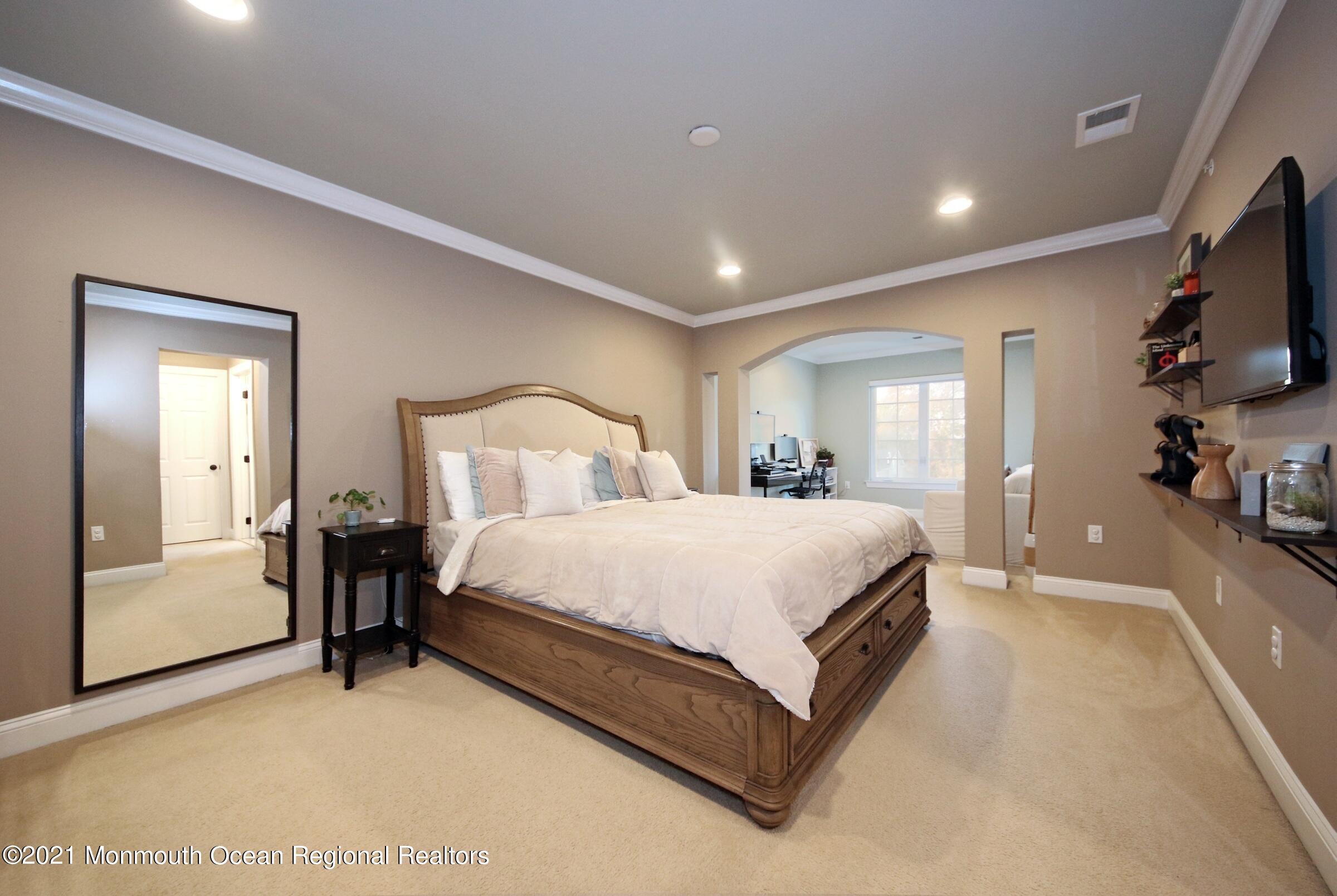 502 Abby Road Middletown, NJ 07748 - Photo 17 of 24 a spacious bedroom with a bed and a flat tv screen on a dresser
