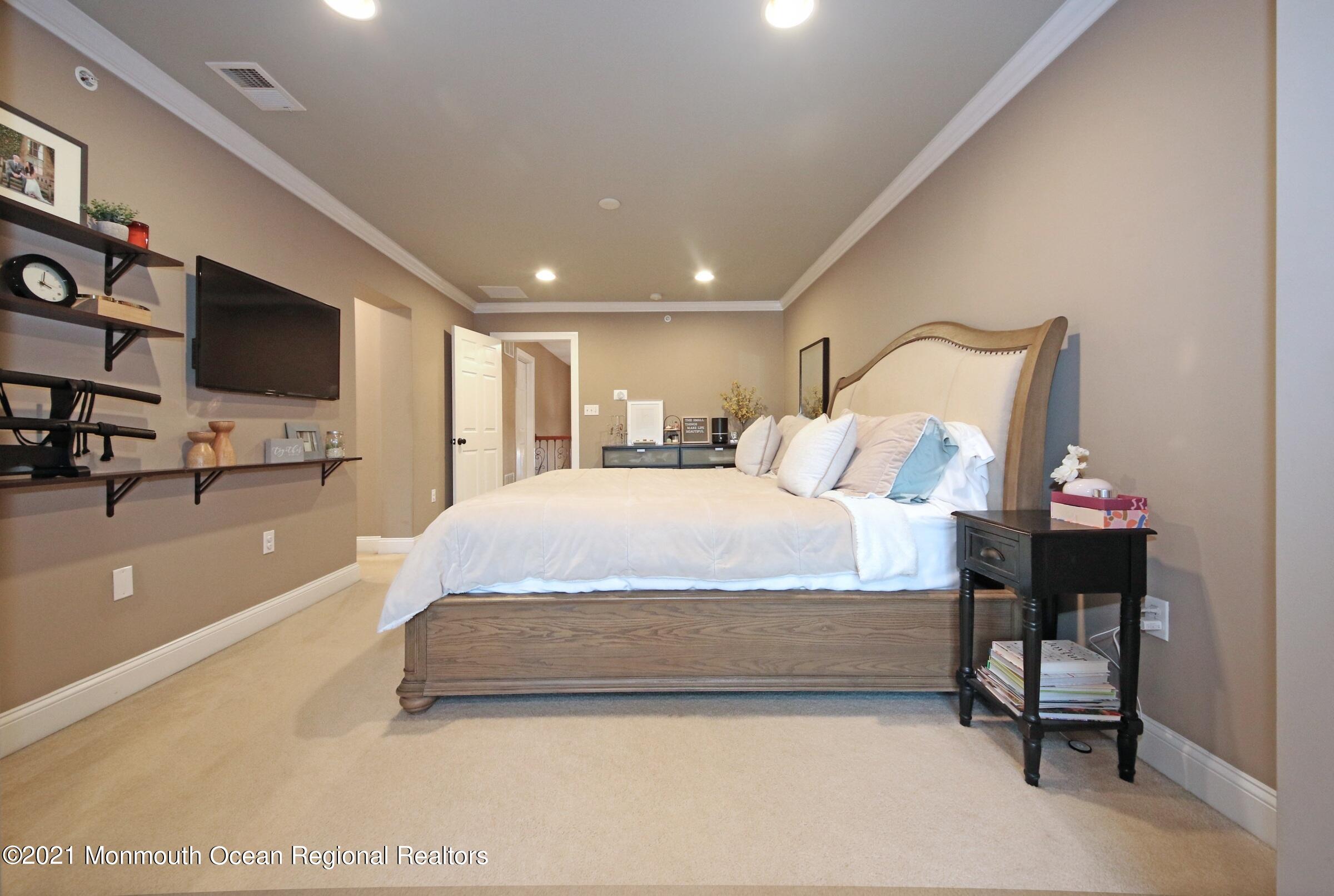 502 Abby Road Middletown, NJ 07748 - Photo 18 of 24 a spacious bedroom with a bed and a flat screen tv