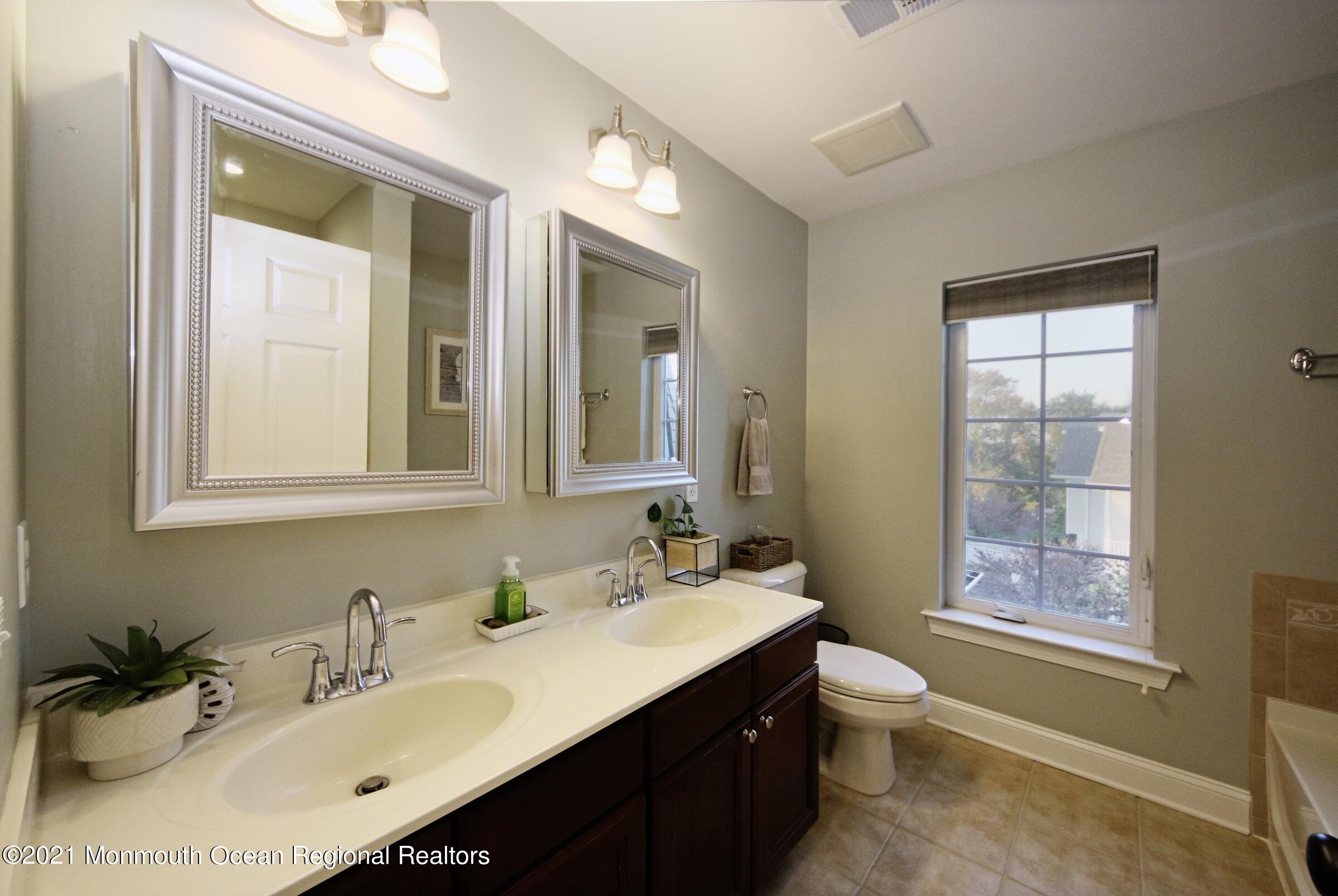 502 Abby Road Middletown, NJ 07748 - Photo 21 of 24 a bathroom with a sink vanity mirror bathtub and a toilet