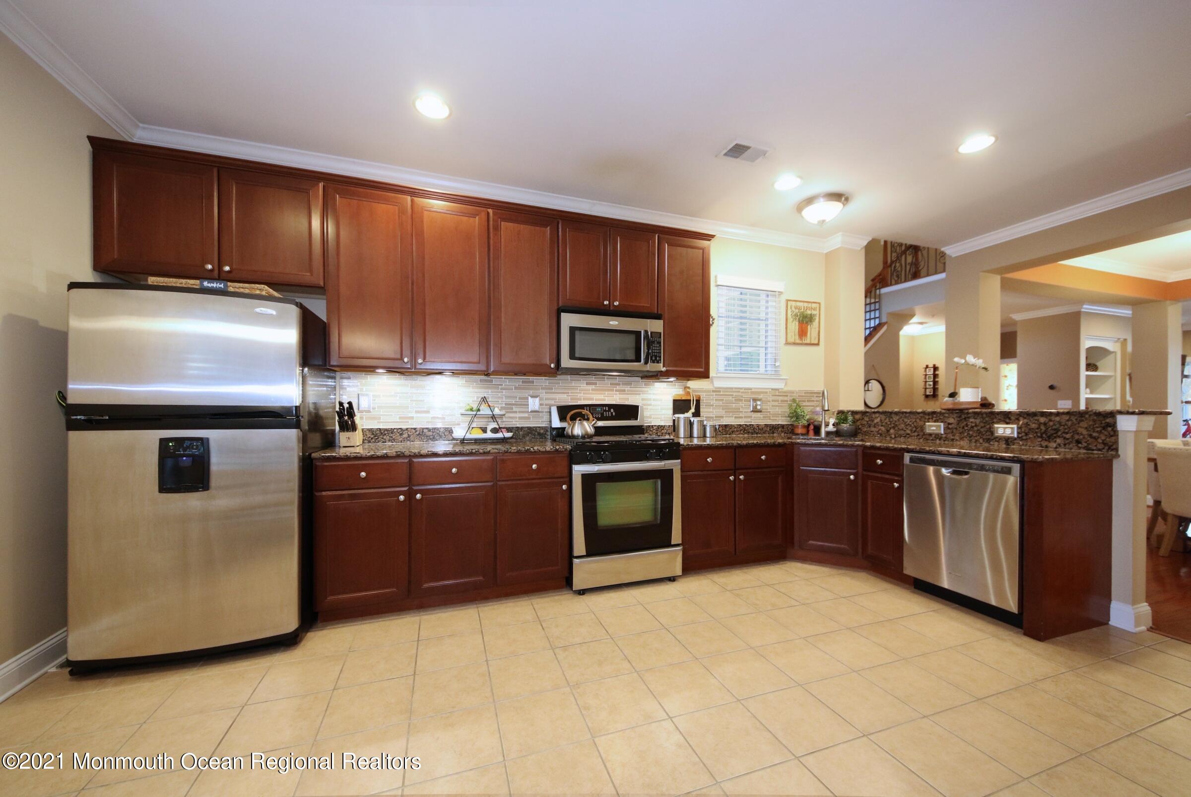 502 Abby Road Middletown, NJ 07748 - Photo 4 of 24 a large kitchen with stainless steel appliances granite countertop a stove a sink dishwasher a refrigerator and a microwave
