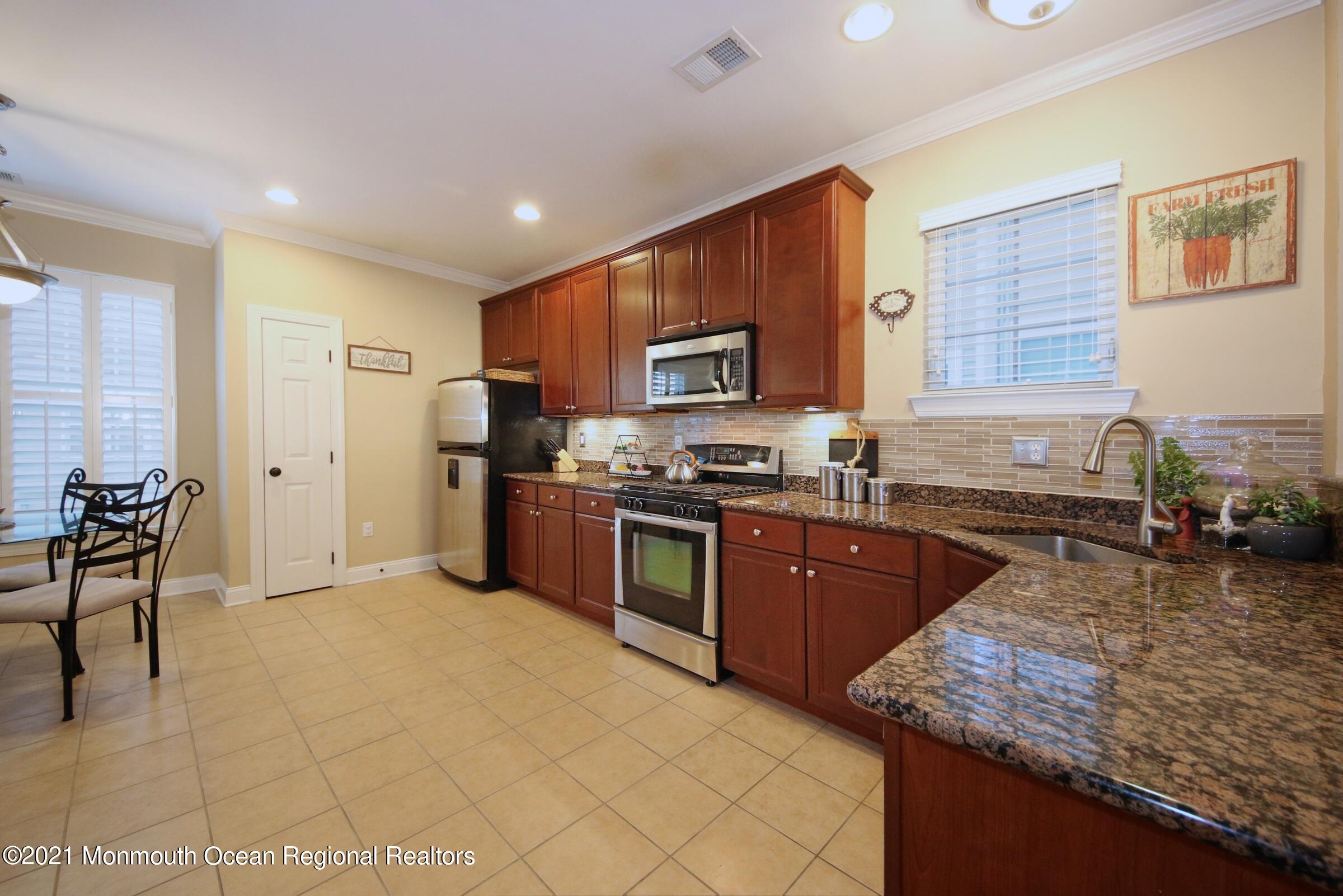502 Abby Road Middletown, NJ 07748 - Photo 5 of 24 a kitchen with stainless steel appliances granite countertop a stove sink and cabinets