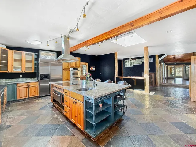 a large kitchen with stainless steel appliances a stove and cabinets