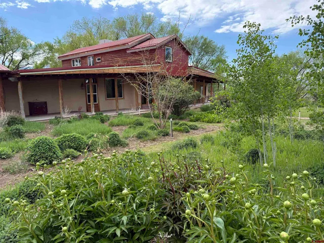 a view of house with yard and outdoor seating