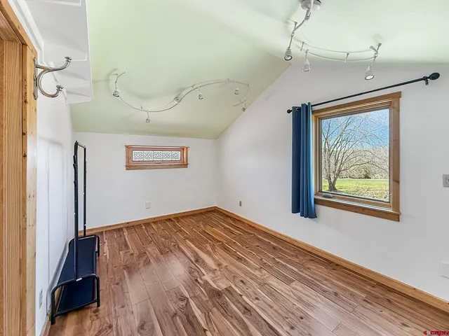 a view of empty room with wooden floor