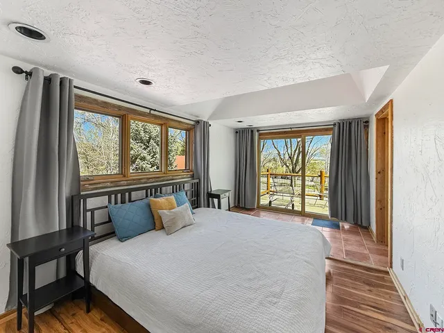 a large bed sitting in a bedroom next to a window