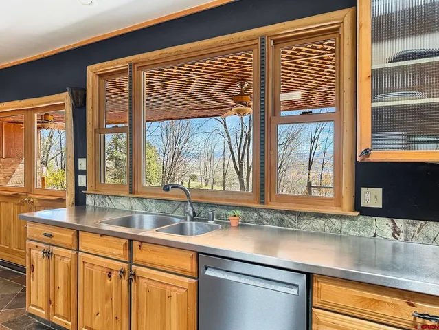 a kitchen with stainless steel appliances granite countertop a sink and a large window
