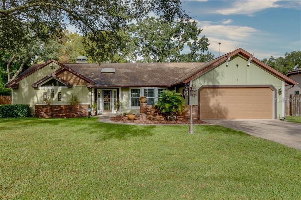 2031 Nobleton Avenue Spring Hill, FL 34608 - Photo 1 of 1 a front view of a house with a garden and porch