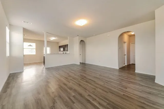 a view of empty room with wooden floor and window