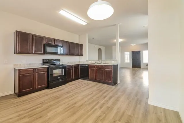 a kitchen with stainless steel appliances granite countertop a stove sink and cabinets