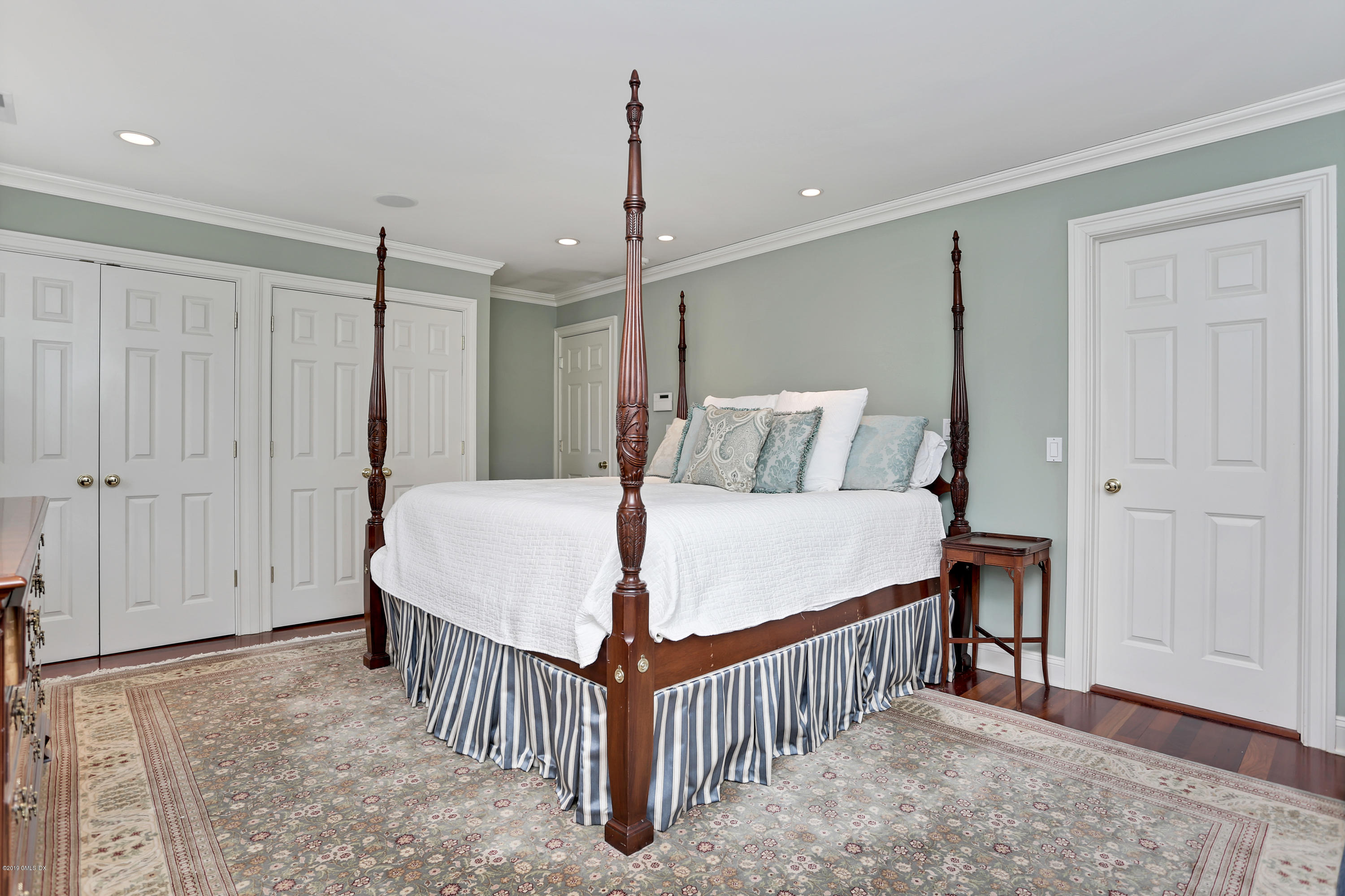 99 Lockwood Road Riverside, CT 06878 - Photo 14 of 21 a bedroom with a bed and a chandelier
