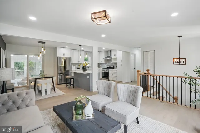a living room with furniture and a dining table with kitchen view