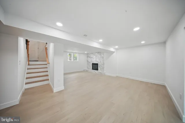 a view of empty room with wooden floor and fireplace