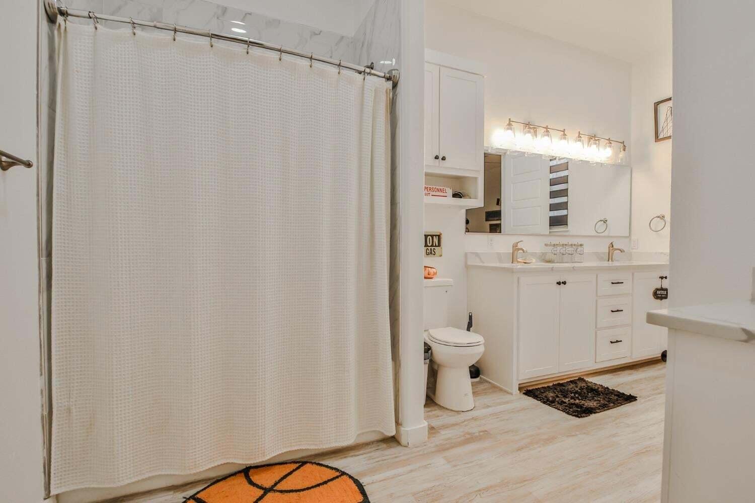 19210 County Road 2240 Lubbock, TX 79423 - Photo 25 of 46 a bathroom with a toilet a sink and a mirror