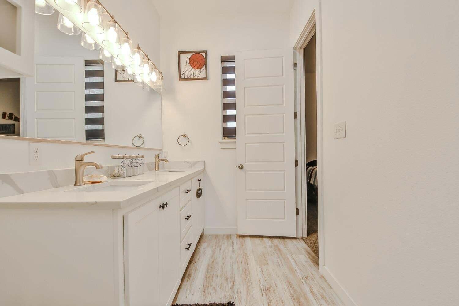 19210 County Road 2240 Lubbock, TX 79423 - Photo 26 of 46 a bathroom with a sink a mirror and a shower