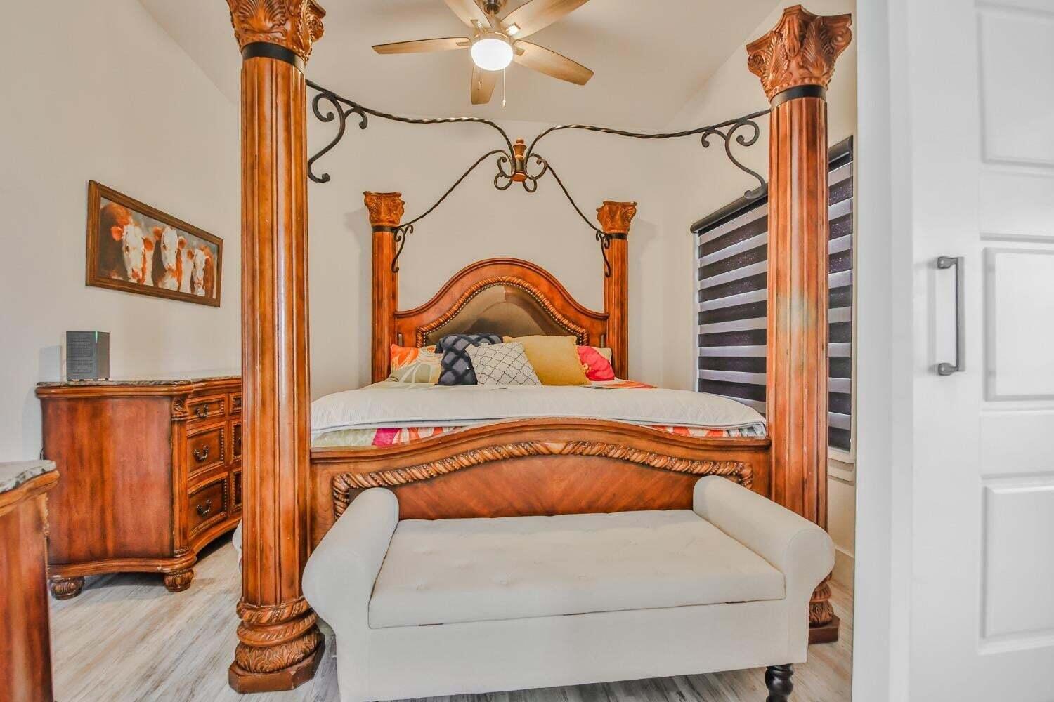 19210 County Road 2240 Lubbock, TX 79423 - Photo 35 of 46 a bedroom with a bed and a dresser with wooden floor